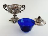 an image of a blue bowl sitting next to a silver cup