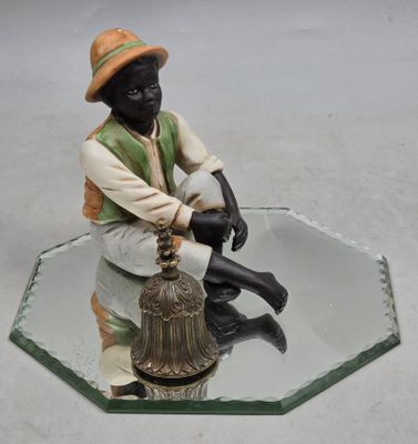 une figurine représentant un homme assis sur une table en verre