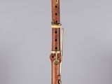 a close up of a wooden clarinet on a clear surface