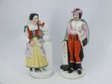 two figurines of a man and a woman standing next to each other