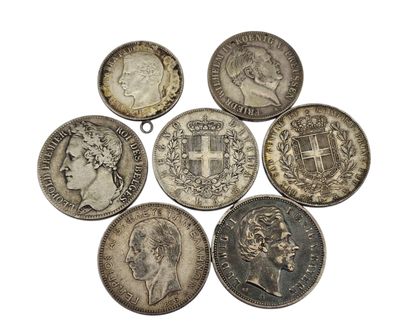 six different british coins are arranged in a circle on a white surface