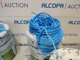 a ball of blue yarn sitting on a table next to a roll of white yarn