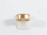 gros plan d'une bague en or sur une surface blanche
