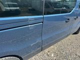 a blue van that is parked on the side of the road