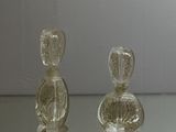 two glass bottles sitting on a glass table
