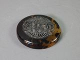 a picture of a tortoise shell button with a lion head on it