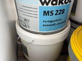 a bucket of water next to a toilet in a room