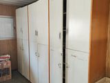 de nombreux réfrigérateurs blancs dans une pièce dont les murs sont recouverts de lambris