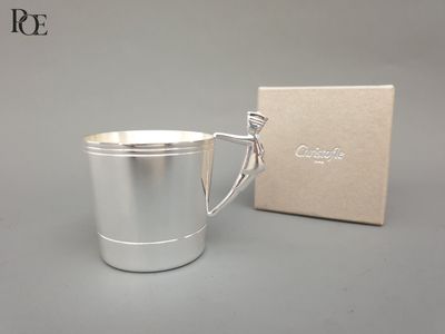 une coupe en argent posée à côté d'une boîte sur une table