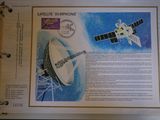 an open book with a picture of a satellite and a space station on it
