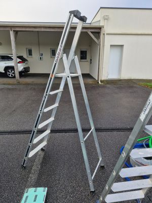 two ladders that are sitting in the parking lot