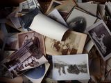 many old photos in a box with a roll of paper