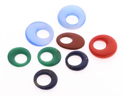 un assortiment d'anneaux en caoutchouc de différentes couleurs sur un fond blanc