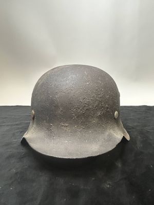 an old helmet is sitting on a black surface with a white background