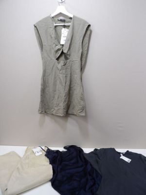 Une chemise blanche et une chemise noire sont posées sur un lit
