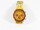 montre jaune et rouge posée sur une surface blanche, sur fond blanc
