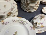 many plates and bowls on a table with a blue table cloth