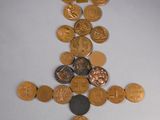 a cross made out of coins on a white surface