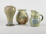trois vases posés l'un à côté de l'autre sur une surface blanche