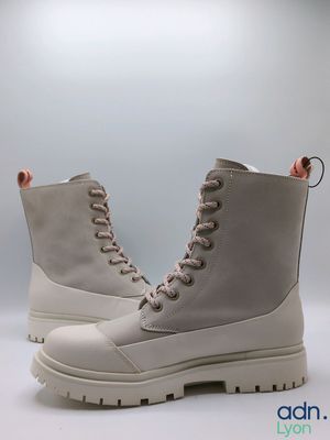 a close up of a pair of white boots on a white surface