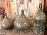 three vases sitting on a shelf in front of a painting