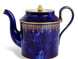 théière bleue et dorée sur fond blanc, avec un fond blanc
