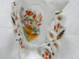 a white vase with a floral design on it