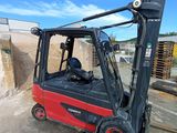 a red forklift truck parked in a parking lot