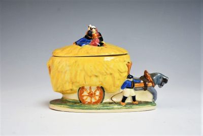 une figurine représentant une calèche tirée par des chevaux, avec un homme et une femme à bord