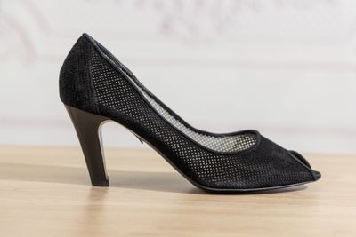Les chaussures de la femme sont posées sur la table en bois près du mur.