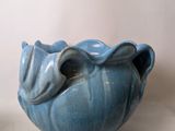 a blue vase with a leaf decoration on it