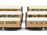 four train cars sitting side by side on a white surface