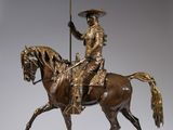statue of a man riding a horse with a flag on it