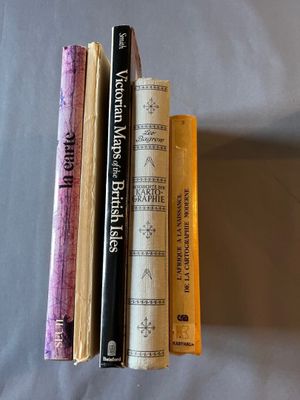 trois livres sont empilés les uns sur les autres sur un lit