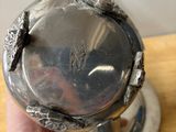 someone is holding a silver plate with a bird on it