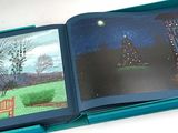 an open book with a picture of a christmas tree in it