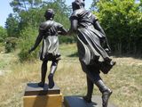 deux statues en bronze représentant une femme et un homme se tenant la main