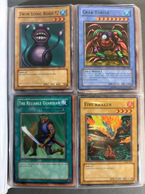 quatre cartes Pokémon différentes dans un étui en plastique posé sur une table