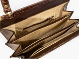 the inside of a brown purse with three compartments and a zipper