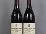 two bottles of wine sitting on top of a table next to each other