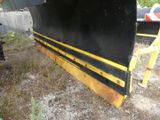an image of a black and yellow boat sitting in the grass