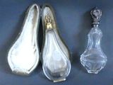 two silver spoons and a glass bottle on a blue surface