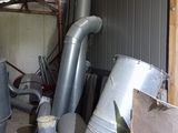 un tas de tuyaux métalliques dans un bâtiment, à côté d'un tas de bois