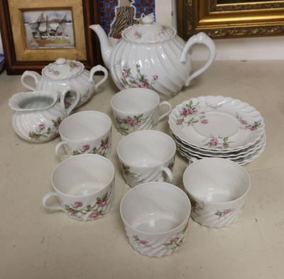 many cups and saucers and a teapot on the table