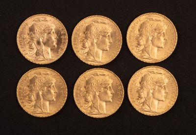 six souverains d'or de tailles et de formes différentes posés sur un fond noir