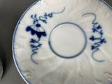 a blue and white plate with writing on it next to a pair of scissors