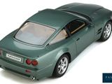 a green toy car that is sitting on a white surface