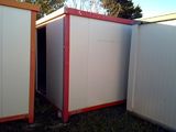 three white and red storage containers in the grass