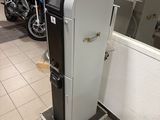 a black and white refrigerator in a room next to motorcycles