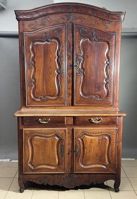 a wooden cabinet with two doors and a drawer on top of it